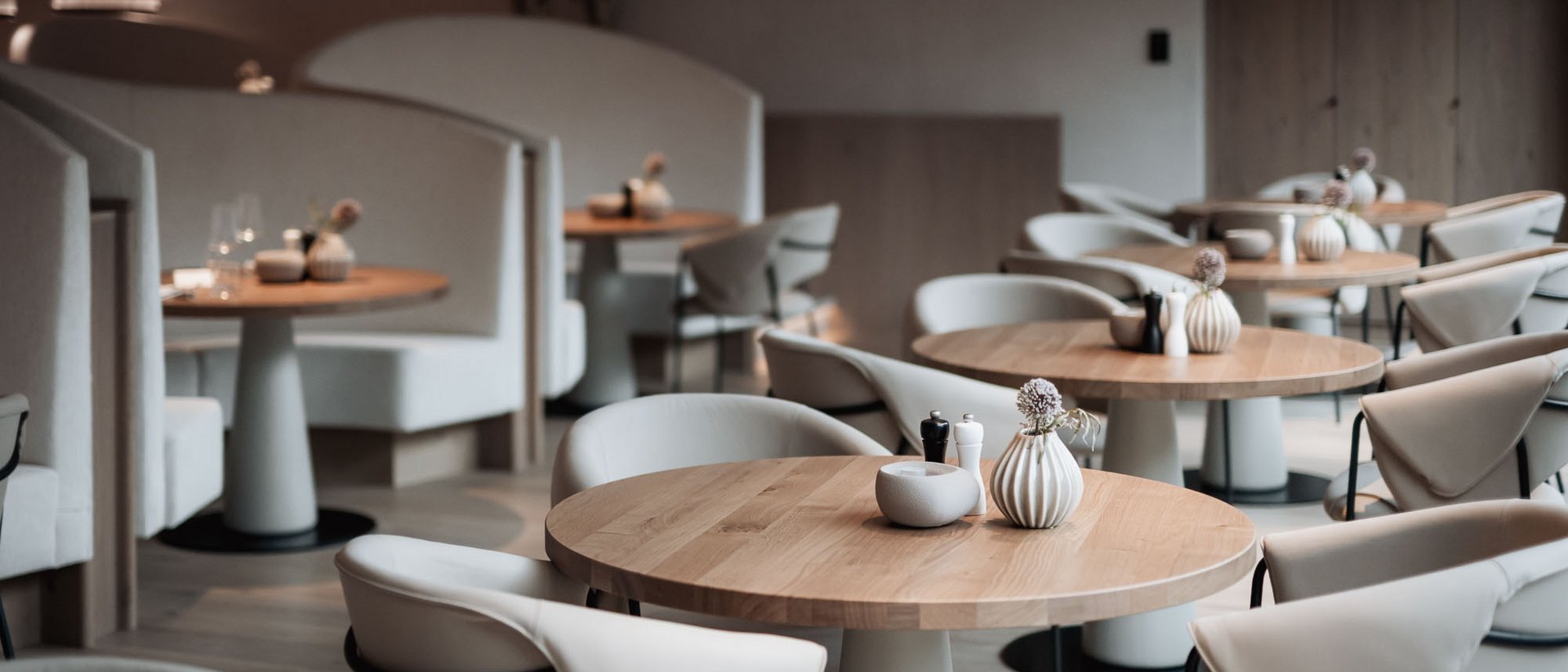 Elegantes und modernes Restaurant mit Holz- und beigen Polstermöbeln