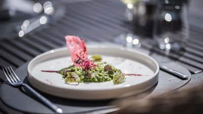 Risotto verde creativo su piatto bianco con guarnizioni rosse e verdi