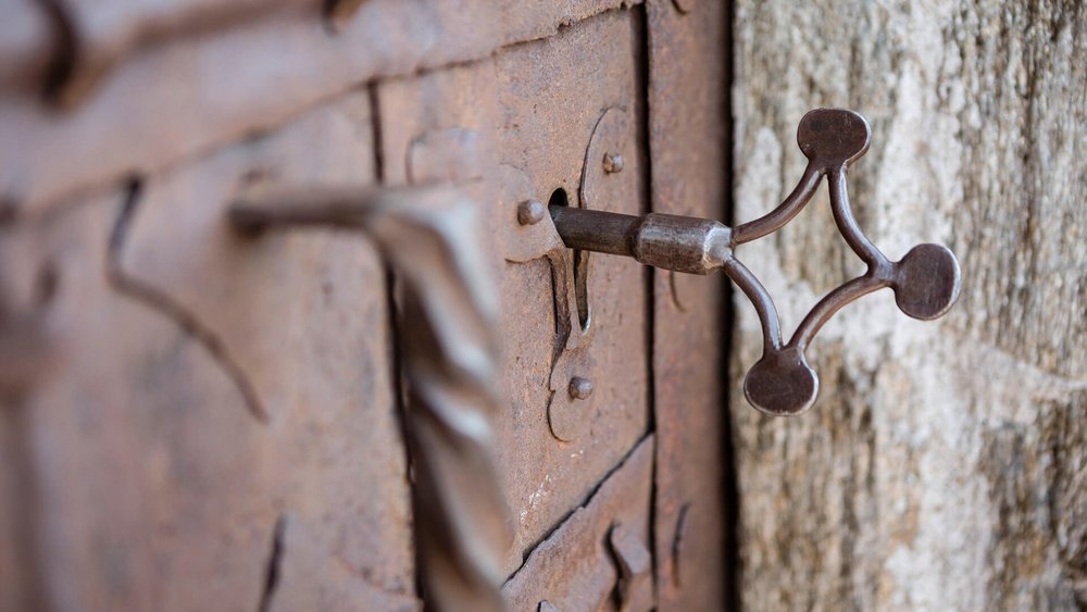 Alte rostige Tür mit einem antiken Metallschlüssel im Schloss
