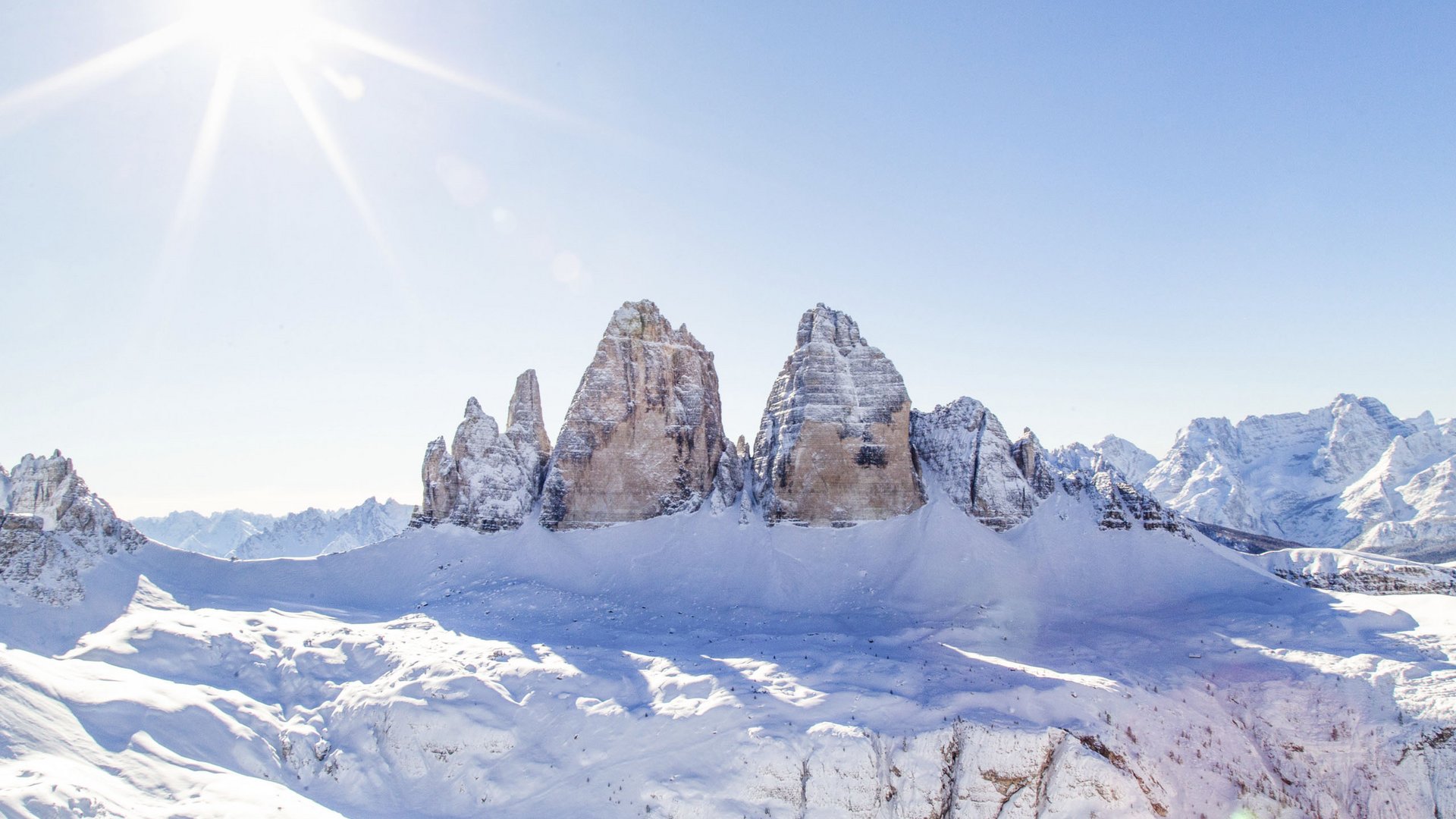 Sonnige verschneite Bergspitzen der Dolomiten bei klarem Himmel