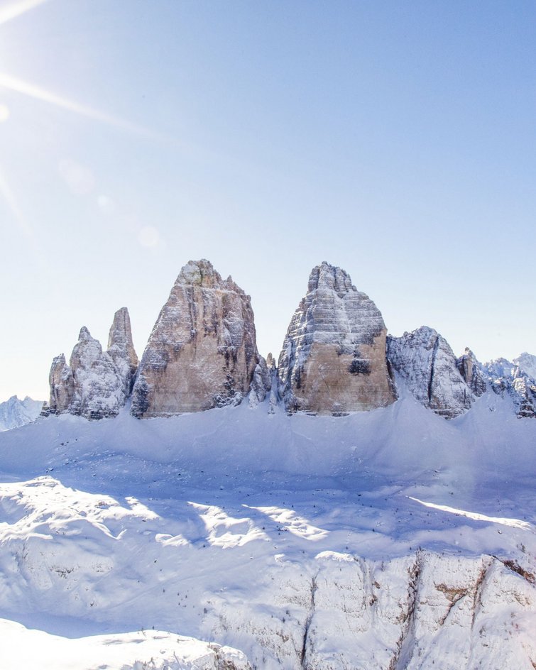 Punte di montagna innevate delle Dolomiti con sole e cielo limpido