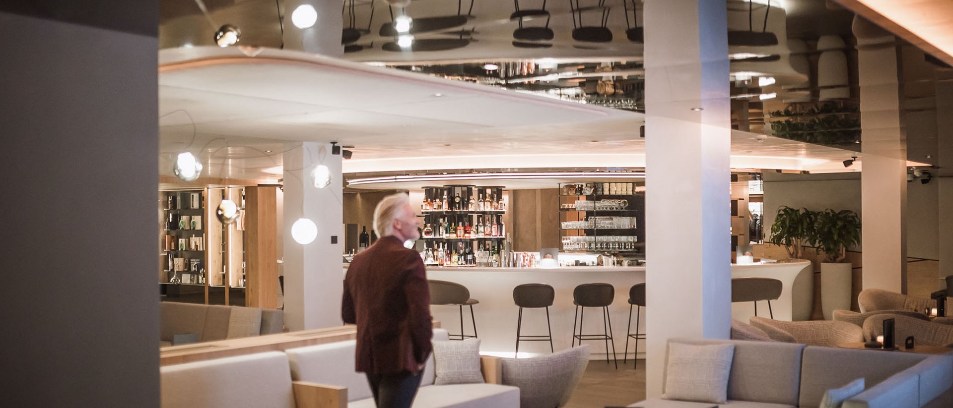Man in lounge bar with sofas and stools