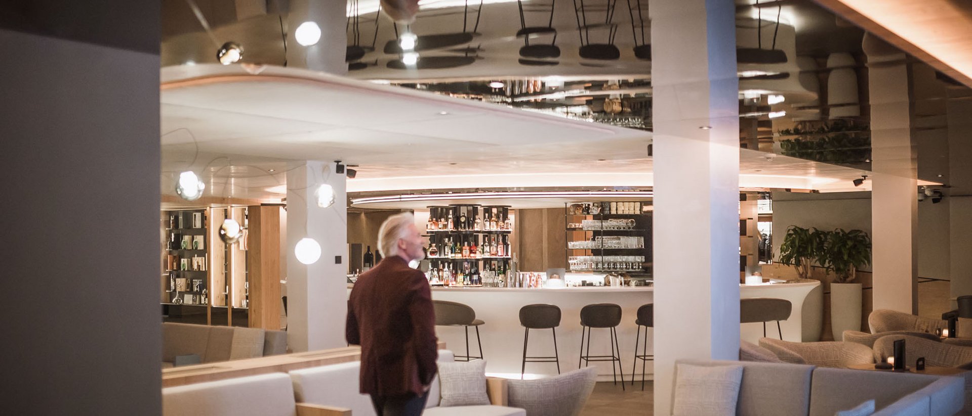 Man in lounge bar with sofas and stools