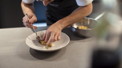 L’esclusività in foto: il nostro chalet in Alto Adige di lusso Cuoco che sistema piccoli bocconcini gourmet su piatto bianco