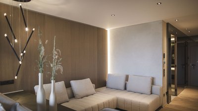 Soggiorno moderno con divano ad angolo chiaro e illuminazione minimalista