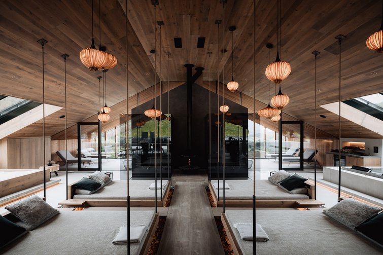 Modernes Spa mit hängenden Betten, Spiegeln und warmen Holzakzenten