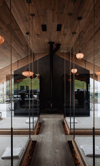 Modern spa with hanging beds, mirrors, and warm wooden accents