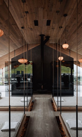 Modern spa with hanging beds, mirrors, and warm wooden accents