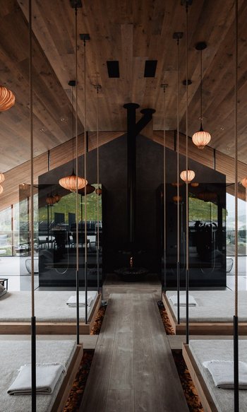 Modern spa with hanging beds, mirrors, and warm wooden accents