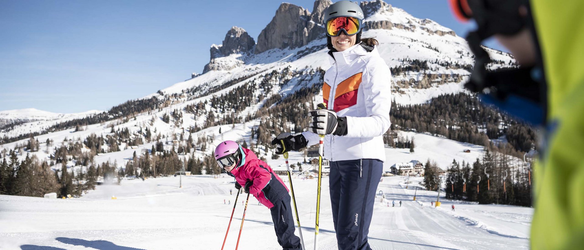 Vacanza sugli sci in famiglia al Plan de Corones Donna e bambino sciando su pendio innevato con montagne sullo sfondo