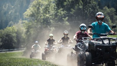 Gruppo di persone che guidano quad su un sentiero polveroso