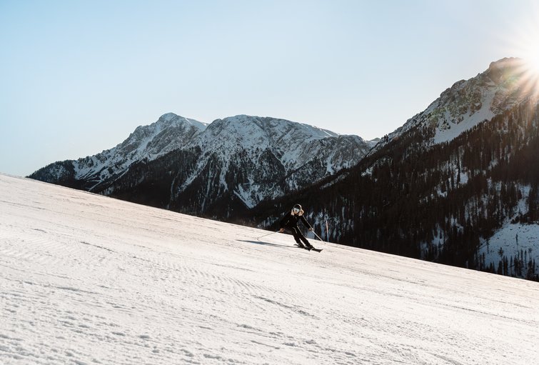Hotel sulle piste del Plan de Corones: divertimento senza fine Sciatore su pendio innevato con montagne sullo sfondo