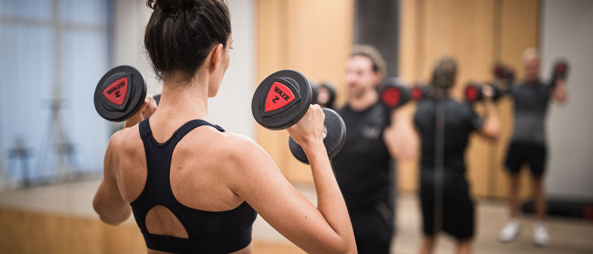 Hotel per yoga in Alto Adige Persone che sollevano pesi davanti a uno specchio in palestra