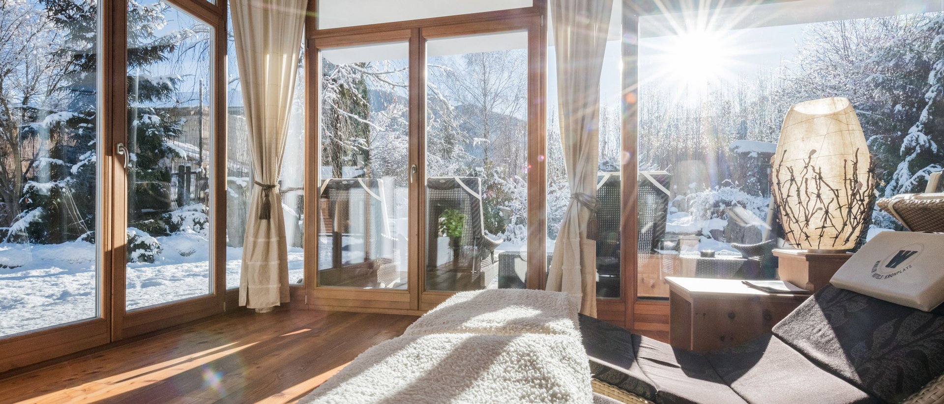 Sala relax luminosa con vista su giardino innevato e sole splendente