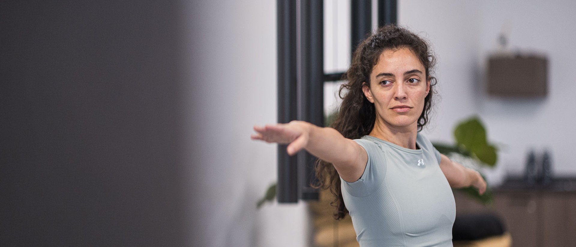 Winklerhotels: relax negli hotel per yoga in Alto Adige Donna che pratica yoga con le braccia distese in una stanza moderna
