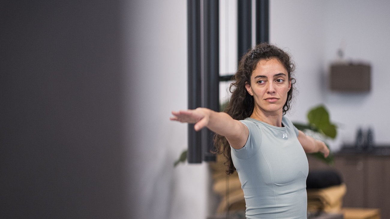 Winklerhotels: relax negli hotel per yoga in Alto Adige Donna che pratica yoga con le braccia distese in una stanza moderna