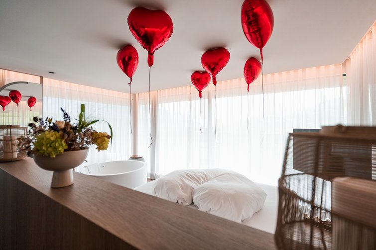 Camera da letto romantica con palloncini rossi a forma di cuore sul soffitto