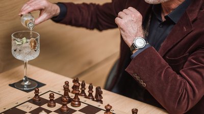 Uomo versa bevanda accanto a scacchiera