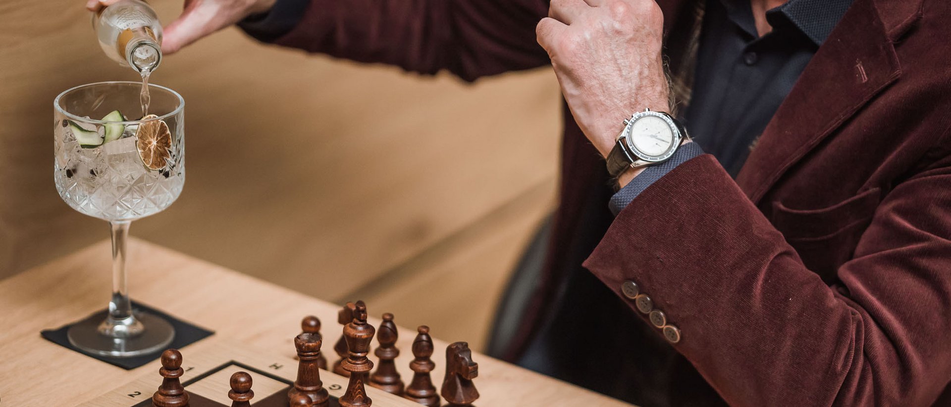 Uomo versa bevanda accanto a scacchiera