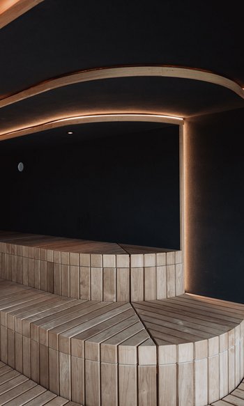 Die Heimat des Strahlens: Ihr Wellnesshotel in Südtirol Moderner Holzbänke Sauna mit indirekter LED-Beleuchtung