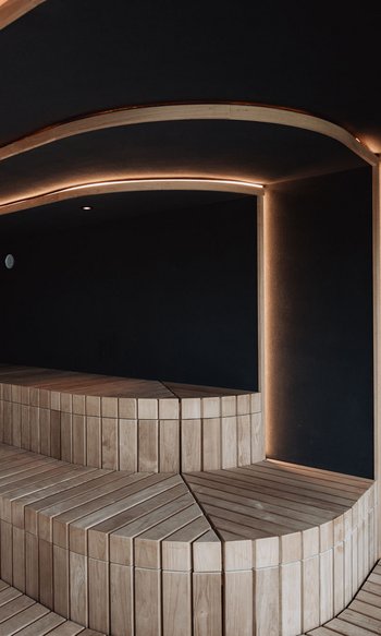 Sauna con panche in legno e illuminazione LED indiretta moderna