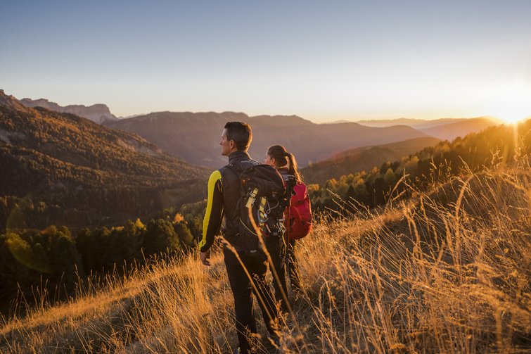 Zwei Wanderer genießen den Sonnenuntergang in den Bergen