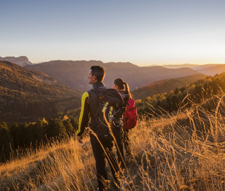 Winkler’s Stories: i nostri alberghi con maneggio di cavalli Due escursionisti ammirano il tramonto sulle montagne