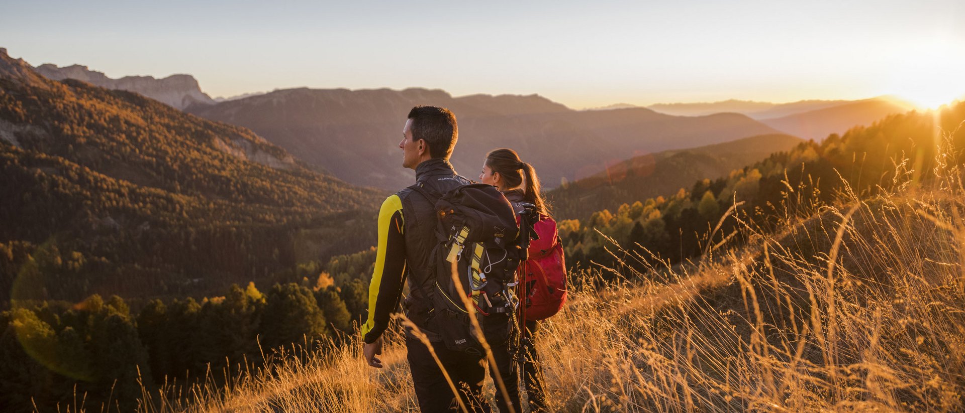 Winklerhotels | Passeggiate piacevoli a settembre Due escursionisti ammirano il tramonto sulle montagne