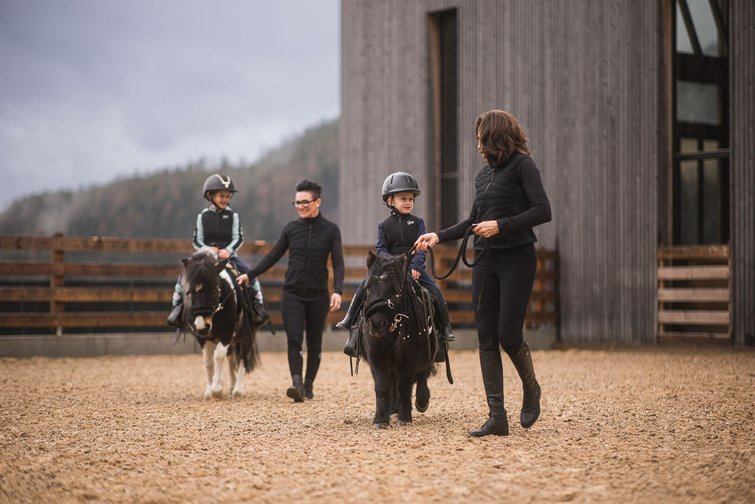 Hotel Winkler: il nostro hotel per famiglie sulle Dolomiti Bambini cavalcano pony con due adulti che li accompagnano nel maneggio