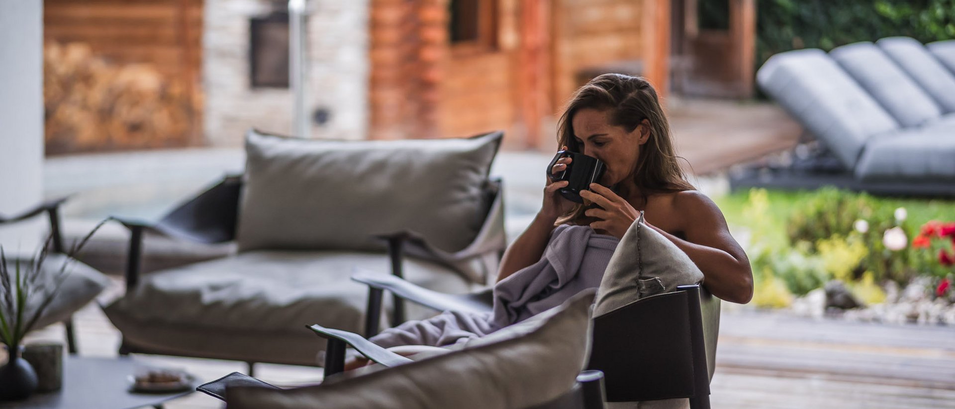 Frau entspannt sich und trinkt aus einer Tasse auf einer Terrasse