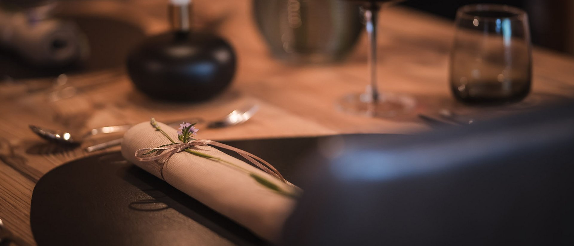 Elegantes gedecktes Esstablett mit Serviette und Weinglas im Hintergrund