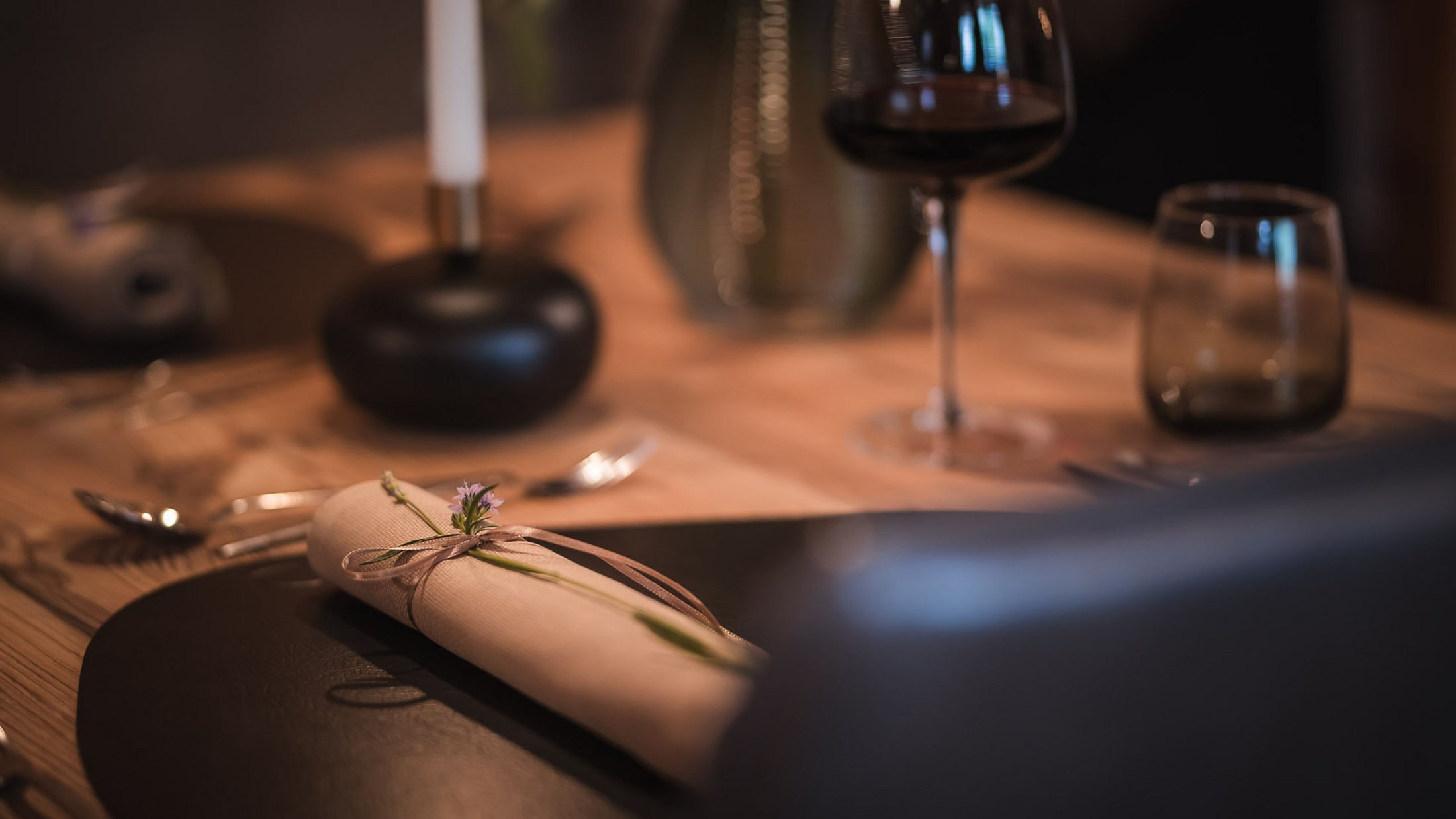 Elegantes gedecktes Esstablett mit Serviette und Weinglas im Hintergrund