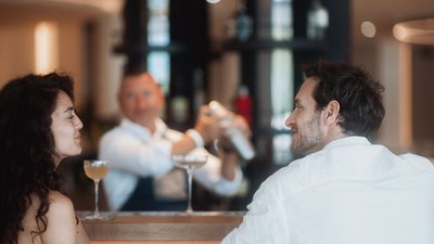 Menschen unterhalten sich in einer Bar mit Getränken am Tisch