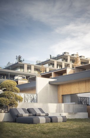 Modern outdoor loungers on grass with contemporary house in the background
