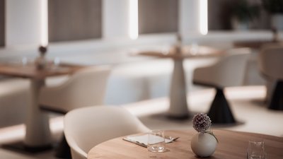 Photos from your hotel in Pfalzen in Val Pusteria/Pustertal Modern restaurant area with wooden tables and flower decorations