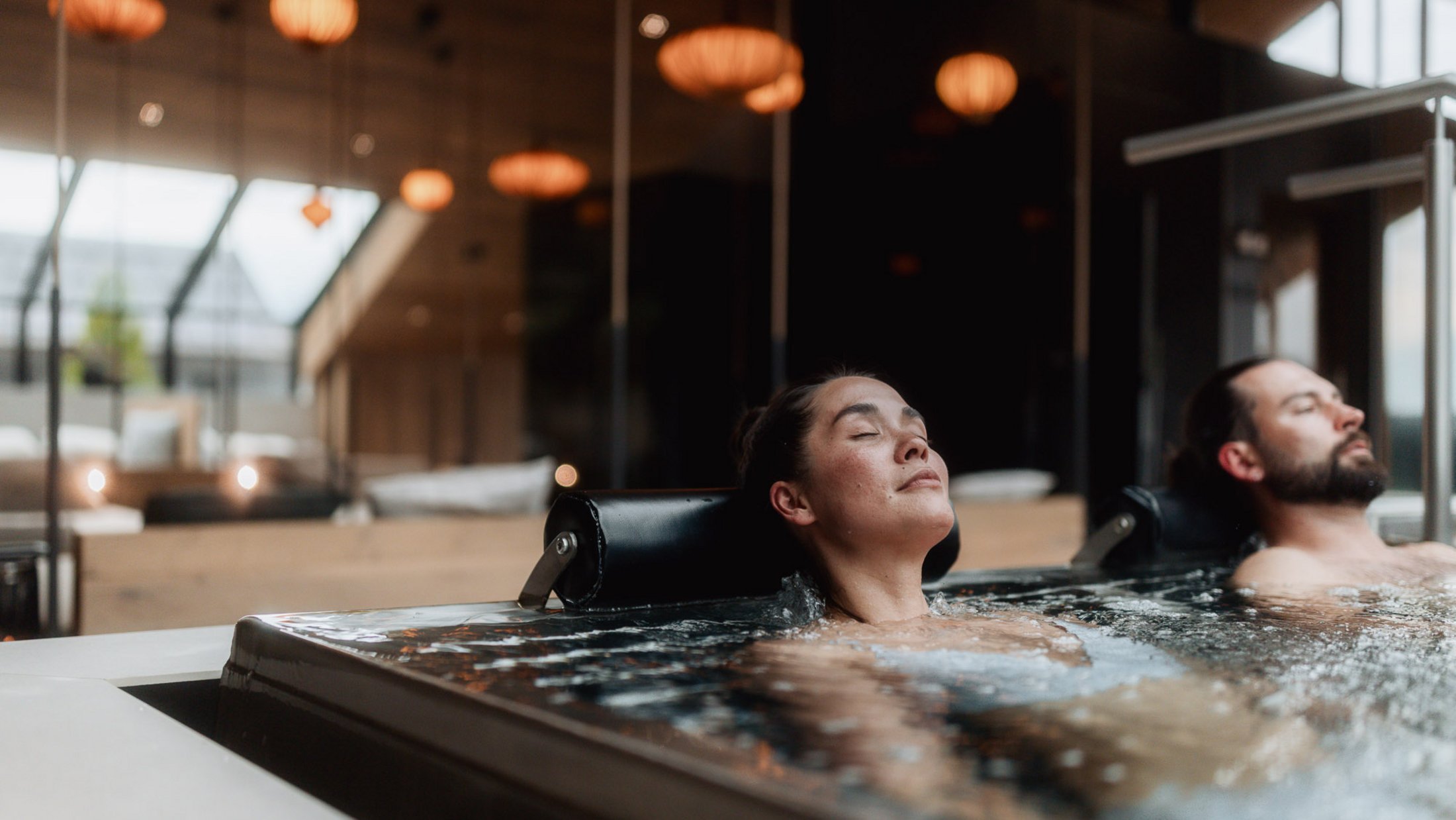 Mann und Frau entspannen in einem modernen Whirlpool in einem Innenbereich