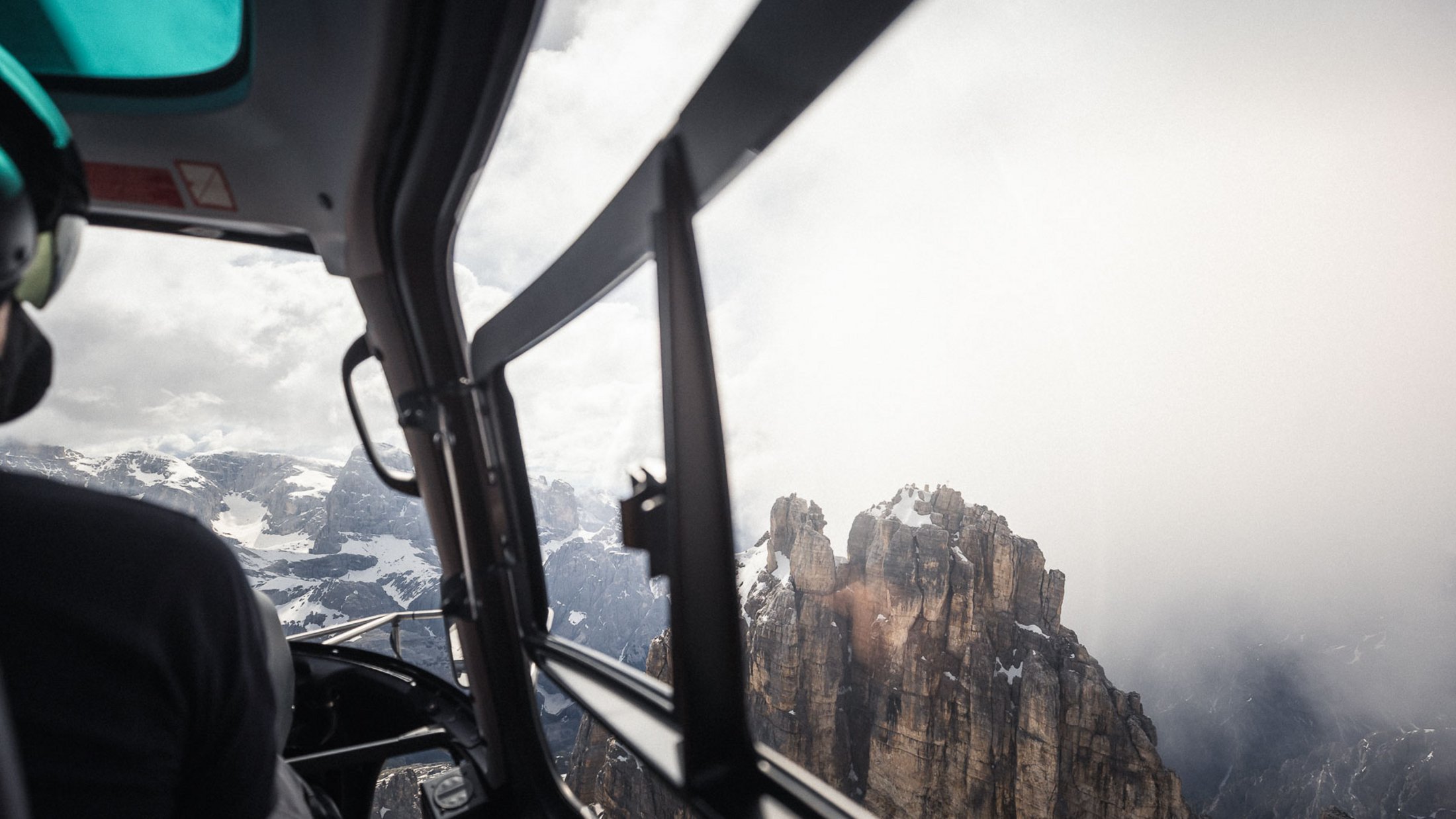 Vista da elicottero su montagne innevate e rocce nella nebbia