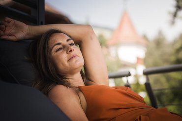 Donna rilassata all'aperto su una sdraio con sfondo sfocato