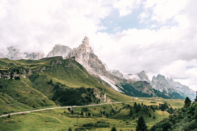 Green hills with mountain peaks and cloudy sky