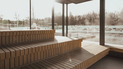 Photos from your hotel in Pfalzen in Val Pusteria/Pustertal Wooden sauna with large windows overlooking a snowy outdoor scene