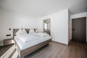 Modern bedroom with double bed and open bathroom window