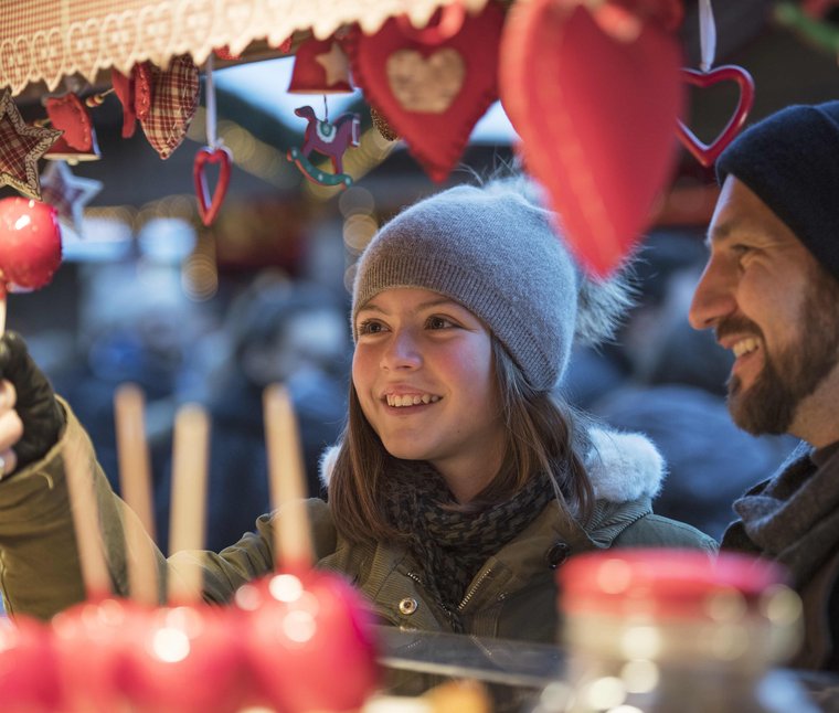 Ragazza compra zucchero filato al mercato di Natale con il padre in inverno