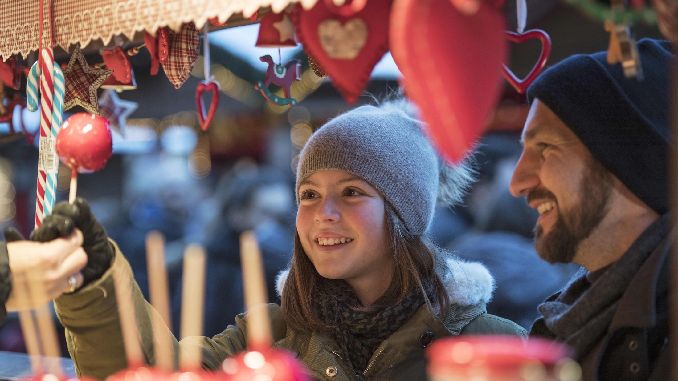 Ragazza compra zucchero filato al mercato di Natale con il padre in inverno