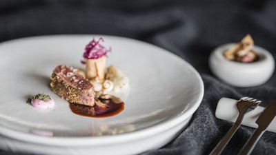 L’esclusività in foto: il nostro chalet in Alto Adige di lusso Piatto gourmet con carne e salsa su un piatto bianco elegante