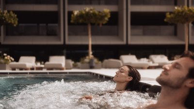 Photos from your hotel in Pfalzen in Val Pusteria/Pustertal Man and woman relaxing in hot tub with bubbling water by hotel pool