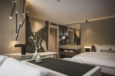 Modern bedroom with double bed and decorative vases on a table