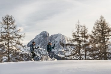 Zwei Personen beim Schneeschuhwandern in verschneiter Berglandschaft