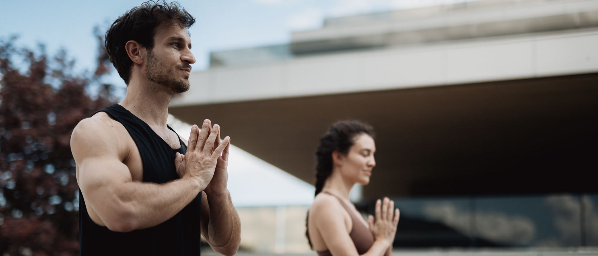 Yoga und Fitness in Ihrem Sporthotel in Südtirol Mann und Frau praktizieren Yoga im Freien mit geschlossenen Augen und gefalteten Händen