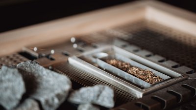 Detailaufnahme eines Metallgrills mit Holzkohle und Gewürzen