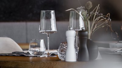 Tavolo in legno elegantemente apparecchiato con calici e decorazioni in ristorante moderno